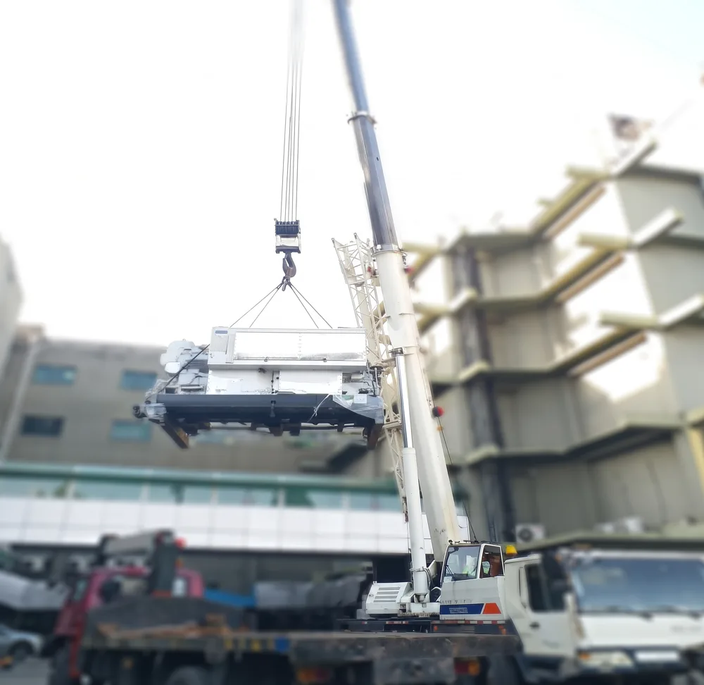 Crane lifting an HVAC unit onto a rooftop